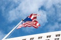 National pride. The US flag against the background of the blue sky and the City Hall Los Angeles