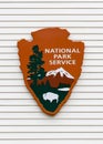 National parks services sign on white exterior wall