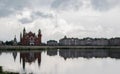 The National Puppet Theatre and houses reflected in the water in a cloudy day. Yoshkar-Ola city, Mari El, Russia.