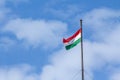 Flag of Hungary also called magyarorszag zaszlaja waiving on a flagpole of Budapest, in front of a blue sunny sky. Royalty Free Stock Photo