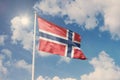 Flag of Norway, National symbol waving against cloudy, blue sky, sunny day