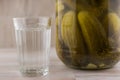 National trait harmful to health: a large jar of pickles and faceted glass of Russian vodka on the left, on a white table, front Royalty Free Stock Photo