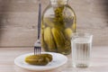 National trait harmful to health: a large jar of pickles and faceted glass of Russian vodka on a white table, a couple of Royalty Free Stock Photo