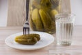 National trait harmful to health: a large jar of pickles and faceted glass of Russian vodka on a white table, a couple of Royalty Free Stock Photo