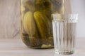 National trait harmful to health: a large jar of pickles and faceted glass of Russian vodka on a white table, front view Royalty Free Stock Photo