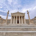 The national university building facade with Athena and Apollo statues standing on Ionian style columns.