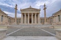 National university classical building facade with Athena and Apollo statues on Ionian style columns under impressive sky.