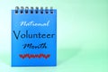 National Volunteer Month reminder on blue desk calendar. Celebration concept.