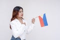 A nationalistic young woman holding one hand to her chest and facing to the right while holding a Philippine flag. Royalty Free Stock Photo