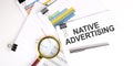 Native Advertising text on the white paper on light background with charts paper