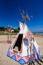 Native american indian tepee and totem pole on the beach blue sk Royalty Free Stock Photo