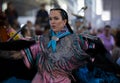 Native American Indian woman in an intricate traditional fancy shawl outfit dancing at a powwow in San Francisco, USA