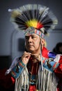 Native American in a traditional outfit putting on a porcupine roach to prepare to dance at a powwow San Francisco, USA