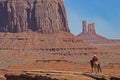 A native American walks his horse in Monument Valley. Royalty Free Stock Photo