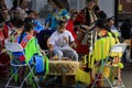 Native Americans dressed in intricate and colorful traditional outfits sing a song and drum at a powwow in San Francisco