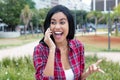 Native latin american young adult woman laughing at phone Royalty Free Stock Photo