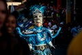 Native man in bright masquerade costume passes by city street at dominican carnival