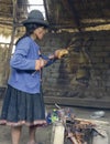 Native Peruvian woman preparing guinea pigs over fire Royalty Free Stock Photo