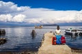 Native woman of the bolivian Andes, in a deck with red bags and totora boat in lake Titicaca, Bolivia.