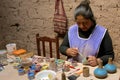 Native woman painting pottery. Peru