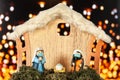 Nativity scene portal with figurines with face masks on a background of defocused lights Royalty Free Stock Photo