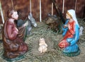 Nativity scene with statues of the Holy family praying in the ma