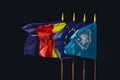 NATO, Romania, European Union and United Nations flags in the wind at night