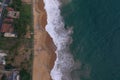 Natural aerial drone bird view day shot of the sea shore with a road, beautiful villas, green trees, yellow sand, turquoise blue