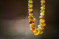 Natural amber beads shining on sun close up. Handmade souvenir of real gems on a dark background, selective focus