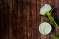 Natural anti-ageing moisturizing face cream decorated with white peony flower on rustic wooden background Royalty Free Stock Photo