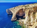 Natural arch window in rock. Couple on the sea. Little people at the bottom of the cliffs. Scenic sea bay with rocky cliff. Top