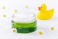 Natural baby cosmetic, cream and chamomile flowers, a duck, selective focus