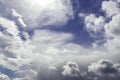 Natural background. Bright blue sky, white fluffy clouds, sun and snow flakes Royalty Free Stock Photo