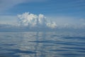 Natural background scene of gradient blue sky horizon and fluffy white cloud above deep blue sea water ripple freezing motion Royalty Free Stock Photo