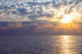 Natural beautiful tropical sundown on the sea with dramatic clouds. Sunset sky backlit by the sun over the ocean. Colorful rays