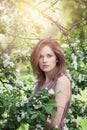 Natural beauty. Beautiful female model girl with brown hair in spring blossom park. Young perfect woman on spring flowers Royalty Free Stock Photo