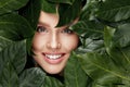 Natural Beauty. Beautiful Woman Face In Green Leaves. Royalty Free Stock Photo