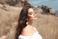 Natural beauty brunette outdoor portrait. Beautiful young bride woman with long wavy hair enjoying in the hay field.  Romantic Royalty Free Stock Photo