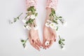 Natural beauty hand cosmetics with flower extract, product. Summer Fashion woman hand on the table with flower, skin care