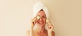 Natural beauty portrait of happy smiling young caucasian woman covers her eyes holds slices of cucumber while drying wet hair with