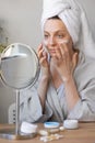 natural beauty and skin care, beautiful young caucasian woman applies cream on her face, beauty of face and body, skin Royalty Free Stock Photo