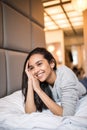 Young pretty woman looking at camera and smiling while lying on the bed at home Royalty Free Stock Photo