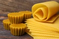 Natural beeswax cake blocks and sheets on wooden table, closeup