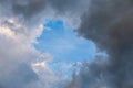 Natural blue sky window in clouds, round gap in solid summer clouds Royalty Free Stock Photo