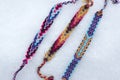 Natural bracelets of friendship in a row, colorful woven friendship bracelets, snow background, rainbow colors, checkered pattern