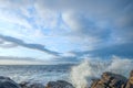 Natural breakwater receiving the onslaught of the waves with views of some islands on the horizon at sunset