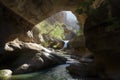 natural bridge of rock and stone in canyon, with rushing stream below