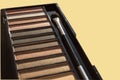 Natural brown Nude eyeshadow palette close-up, with tassel isolated on yellow pastel background