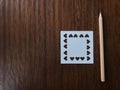 Natural brown wood pencil and white square blank paper which was punched in heart shape Royalty Free Stock Photo