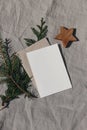 Natural Christmas stationery still life. Blank greeting card, invitation mock up with wooden star ornament and fir